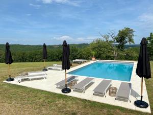 a swimming pool with chairs and umbrellas at Domaine de Cazal - Chambres d'Hôtes avec piscine au cœur de 26 hectares de nature préservée in Saint-Cyprien