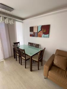 a dining room with a table and chairs and a couch at Golden Apartment in La Garita