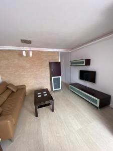 uma sala de estar com um sofá e uma televisão de ecrã plano em Golden Apartment em La Garita