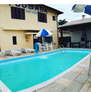a swimming pool in front of a hotel at Pousada Marambaia in Caraguatatuba