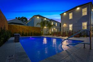 a swimming pool in front of a house at night at Stunning 4BR-5BR near French Quarter Homes by Hosteeva in New Orleans