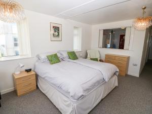 プスヘリにあるSea View Apartmentのベッドルーム1室(白いシーツと緑の枕が備わるベッド1台付)