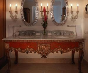 a bathroom with two sinks and two mirrors at Palacio Nazarenas, A Belmond Hotel, Cusco in Cusco