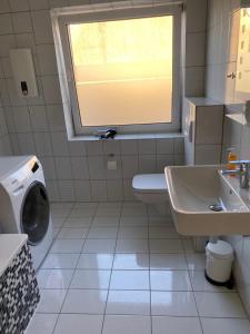 łazienka z umywalką, toaletą i oknem w obiekcie Zur Sonnenblume w mieście Gangelt