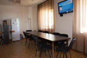 Sala de conferencias con mesa, sillas y TV en Cabana Andreea Telescaun, en Ranca