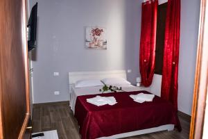 Piccola camera con letto con tende rosse. di La casa dei Fiori a Trapani
