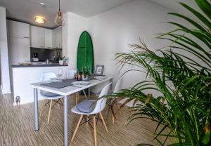 a kitchen with a table and chairs and a surfboard on the wall at Über den Dächern von Kirchheim, Modernes Apartment in Kirchheim unter Teck