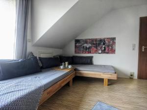una habitación con 2 camas y un sofá en una habitación en Über den Dächern von Kirchheim, Modernes Apartment en Kirchheim unter Teck