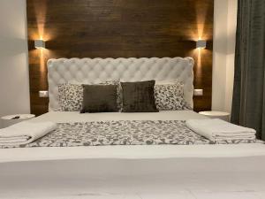uma cama branca com uma grande cabeceira e almofadas brancas em Vatican G&G Suites em Roma