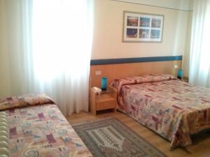 ein Hotelzimmer mit 2 Betten und einem Tisch in der Unterkunft Hotel Montepiana in Mestre