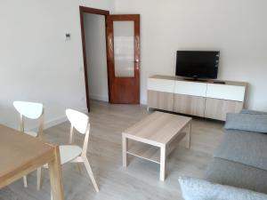 a living room with a tv and a table and chairs at Apartamento boltaña in Boltaña