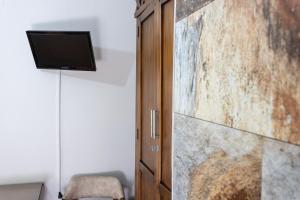 エル・プエルト・デ・サンタマリアにあるHostal Costa Luzの木製のドアと壁にテレビが備わる客室です。