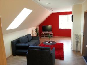 sala de estar con sofá y TV en ferienwohnung mertens, en Westerstede