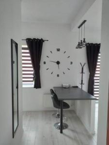 Apartamencik na Doby - Lubin في لوبين: غرفة بها ساعة على الحائط وطاولة