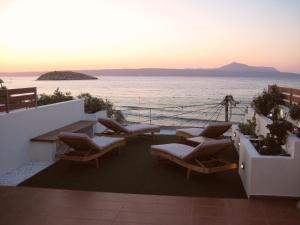 a balcony with chairs and a view of the ocean at Panos Apartment in Almirida