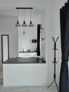 a white room with a counter with lights and a mirror at Apartamencik na Doby - Lubin in Lubin