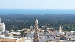 una vista su una città con una statua in primo piano di Dimora Agata 21 a Ostuni