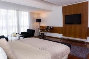 a hotel room with a bed and a flat screen tv at Design Suites Buenos Aires in Buenos Aires