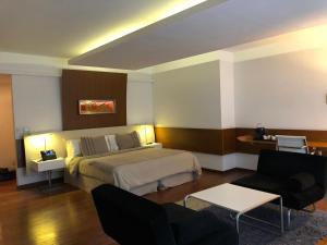 um quarto de hotel com uma cama, uma mesa e cadeiras em Design Suites Buenos Aires em Buenos Aires