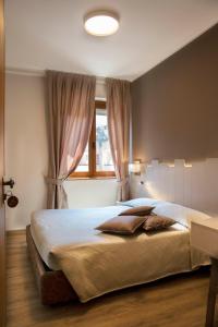 a bedroom with a large bed with a window at Albergo Milano in Boario Terme