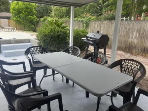 a table and chairs with a grill on a patio at Lovely oasis with private swimming pool 4,6,8 f deep in Gulf Breeze