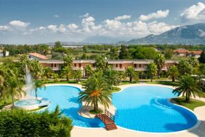 z widokiem na basen z palmami i wodospadem w obiekcie Minerva Resort Hotel w mieście Paestum