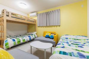 sypialnia z 2 łóżkami piętrowymi i krzesłem w obiekcie City Garden - Vacation STAY 87278 w mieście Fukuoka