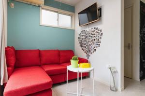 a living room with a red couch and a heart wall at City Garden - Vacation STAY 87278 in Fukuoka