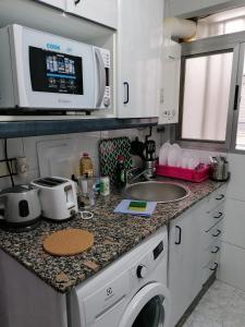 a kitchen with a washing machine and a microwave at PISO EN MALVARROSA in Valencia