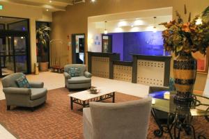 een lobby met stoelen en een tafel en een vaas met bloemen bij Holiday Inn Express Chihuahua, an IHG Hotel in Chihuahua