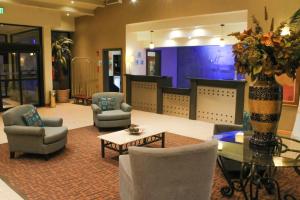 a lobby with chairs and a table and a vase of flowers at Holiday Inn Express Chihuahua, an IHG Hotel in Chihuahua