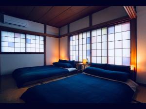 a room with two beds and two windows at Taisho Motor Wir zen - Vacation STAY 88575 in Hakone