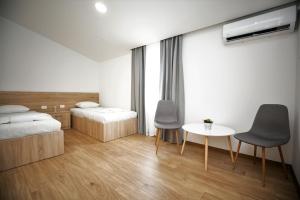 sypialnia z 2 łóżkami, stołem i krzesłami w obiekcie APARTMANI M&J Međugorje w Medziugorie