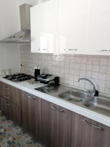 a kitchen with a sink and a stove at Casa Maris in Santo Stefano di Camastra