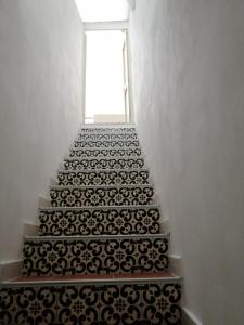 a stairway with black and white tile on the stairs at Casa Maris in Santo Stefano di Camastra