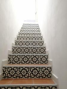 a white staircase with a black and white pattern on it at Casa Maris in Santo Stefano di Camastra