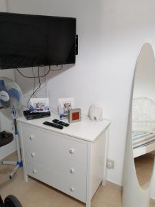 a white dresser with a flat screen tv on top of it at Casa Maris in Santo Stefano di Camastra