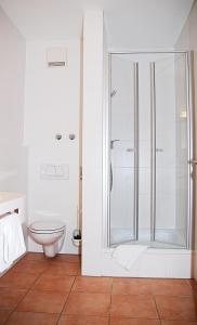 y baño blanco con ducha y aseo. en Hotel Isartaler Hof en Wolfratshausen