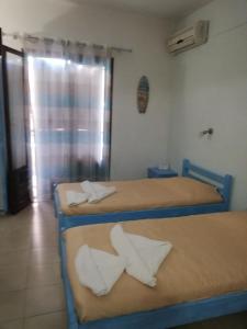 a room with three beds with white pillows on them at Salvanos Residence in Ipsos