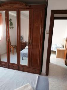 a bedroom with a large wooden cabinet with mirrors at PISO EN MALVARROSA in Valencia