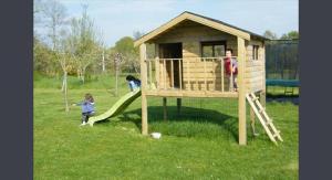 un niño en un tobogán en una casa de juegos en Chambres d'Hôtes Ferme de Kereven, en Clohars-Fouesnant