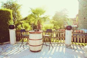 een patio met een vat en stoelen en een hek bij Cà Donzella in Lazise