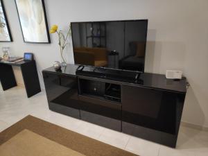 a large black entertainment center with a large screen tv at Faro Stadium Flat in Faro