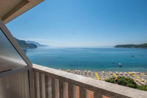 a balcony with a view of a beach and the ocean at Poseidon The Beach Hotel in Budva
