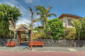 a group of benches sitting outside of a restaurant at Hotel San Vicente Galapagos in Puerto Villamil