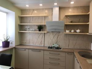 a kitchen with white cabinets and a sink at Comfy Retreat on Kotsubinsky street in Vinnytsya