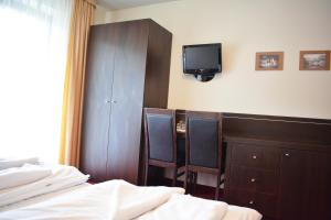 a bedroom with a bed and a cabinet and a tv at Willa Halka in Zakopane