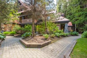 a house with a tree in the middle of a driveway at Sunpath by Outpost Whistler in Whistler