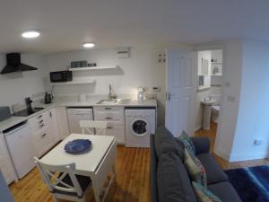uma cozinha e sala de estar com um sofá e uma mesa em Grenane Heights Getaway em Kenmare