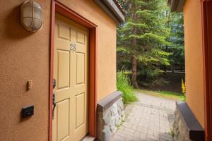 una entrada a una casa con puerta y pasarela en Sunpath by Outpost Whistler, en Whistler